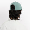 back view of ciele athletics CRWCap short brim unisex running hat with shorter brim from the Lifestyle Edition collection, in silver pine color, on a model